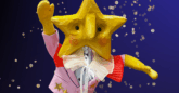 a puppet with a star-shaped face against a painted blue background