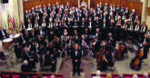 A band and choir dressed smartly looking up at the camera