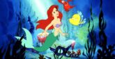 A cartoon mermaid with red hair floats in the ocean with a red crab and yellow fish