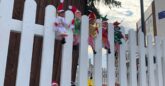 Ten elves in fancy dress sit on the fence in front of the Christmas tree in Southend High Street.